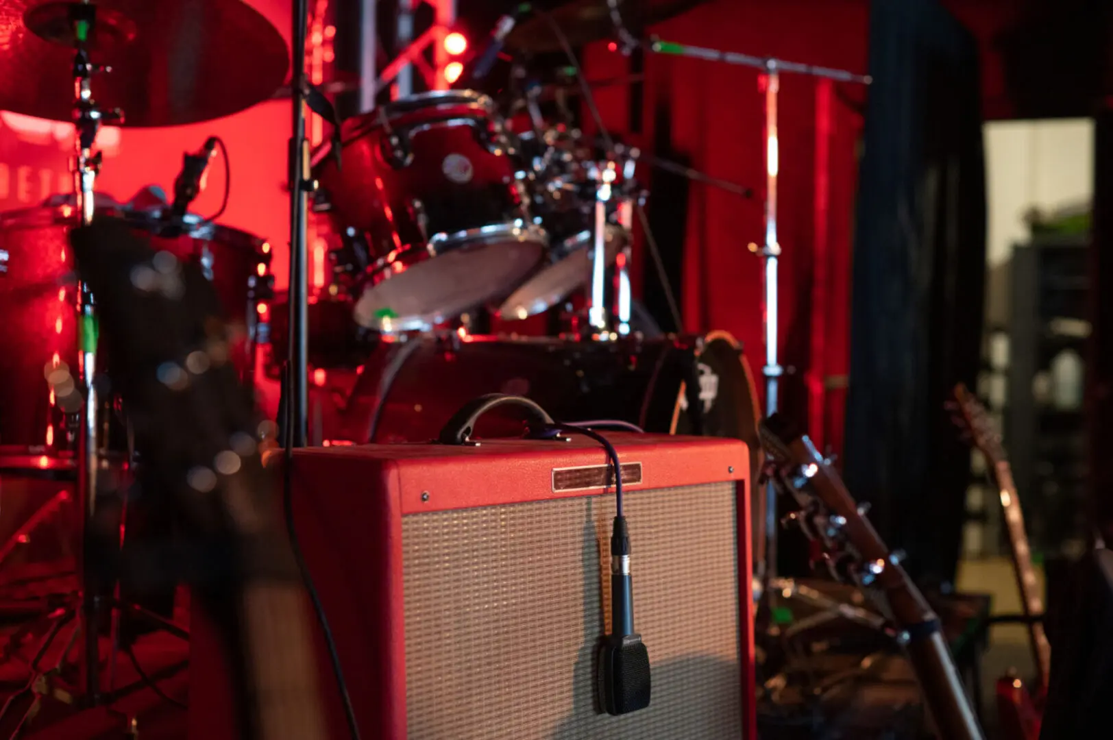 Guitar amp and drums with red lighting
