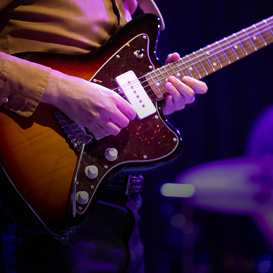 Close-up of hands on guitar strings